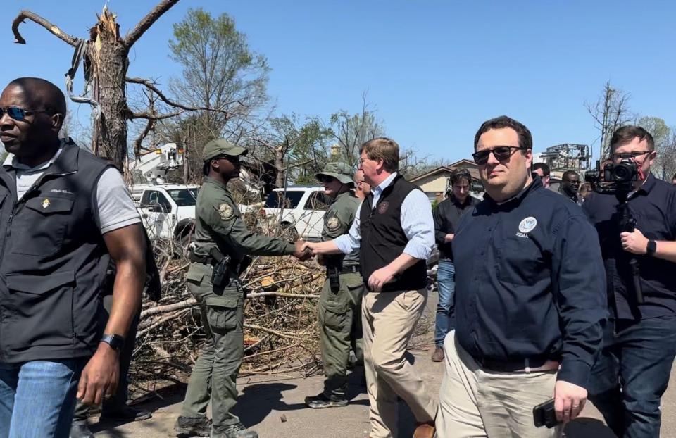 Gov. Tate Reeves surveys the damage Sunday in Rolling Fork. The town took a direct hit from Friday's tornadoes that left 25 dead across the state.