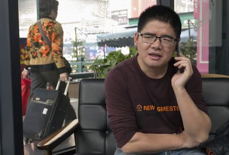 Zeng Feiyang, director of the Guangdong Panyu Migrant Workers Center, talks on his phone during an interview in Guangzhou, Guangdong province, January 20, 2015. REUTERS/Alexandra Harney