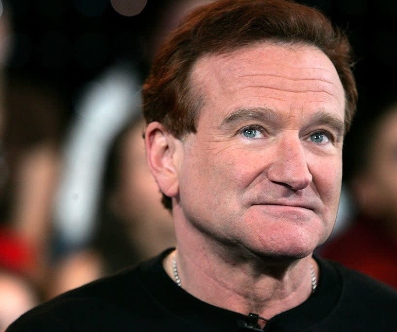 Robin Williams on a red carpet, looking up