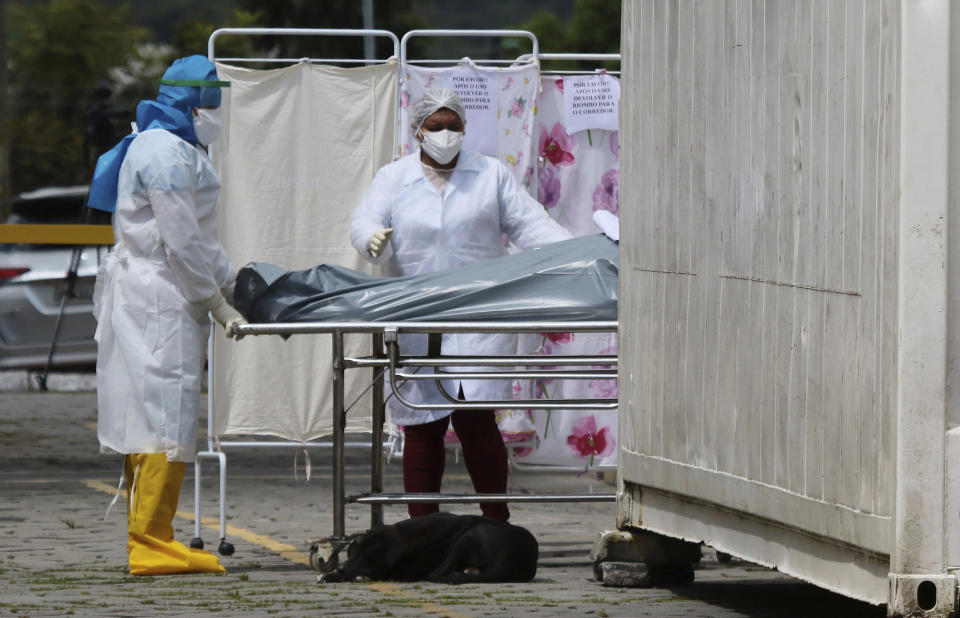 The covered body of a victim of COVID-19 is transported by health workers to a cold storage area at the Joao Lucio Hospital in Manaus, Amazonas state, Brazil, Friday, April 17, 2020. (AP Photo/Edmar Barros)