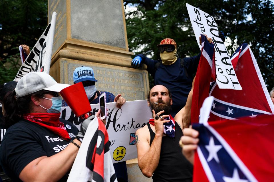 Anti- and pro-Confederate statue protestors clash with one another at a Confederate monument located in Springwood Cemetery Saturday, Aug. 1, 2020.