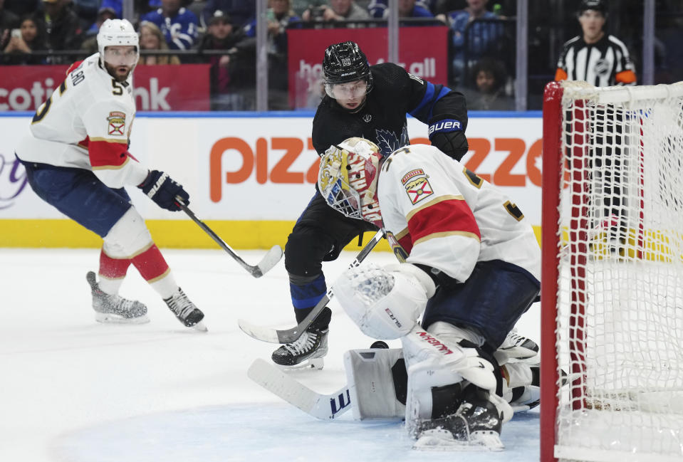 Florida Panthers goaltender Alex Lyon (34) stops Toronto Maple Leafs forward Calle Jarnkrok (19) as Panthers defenseman Aaron Ekblad (5) looks on during the second period of an NHL hockey game in Toronto on Wednesday, March 29, 2023. (Nathan Denette/The Canadian Press via AP)