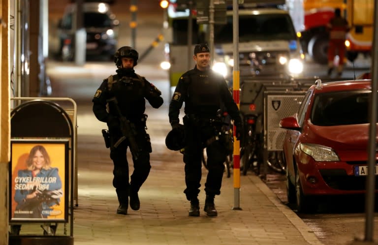Swedish police officers patrol after a beer truck ploughed into a crowd outside a busy department store in central Stockholm, killing four and injuring 15