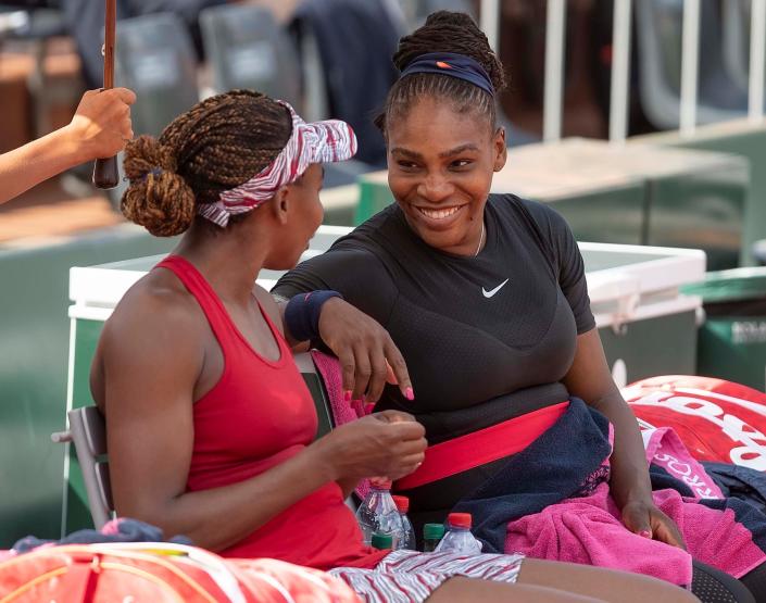 Venus, left, and Serena Williams talk during a break of a doubles match at the 2018 French Open at Roland Garros in Paris.