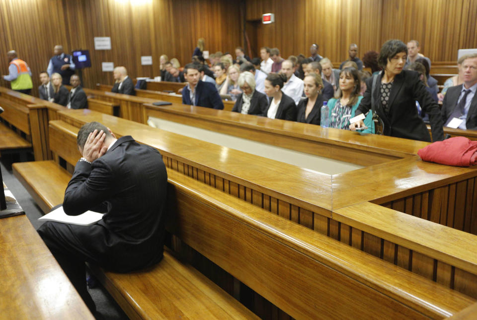 Oscar Pistorius blocks his ears inside the high court on the second day of his trial in Pretoria, South Africa, Tuesday, March 4, 2014. Pistorius is charged with murder for the shooting death of his girlfriend, Reeva Steenkamp, on Valentines Day in 2013. (AP Photo/Kim Ludbrook, Pool)