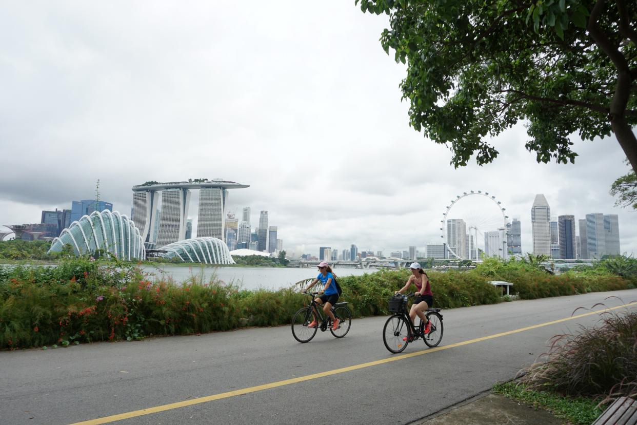 Cyclists ride along Marina Bay overlooking the financial business district in Singapore on July 14, 2020. - Singapore plunged into recession in the second quarter as the economy contracted more than 40 percent, preliminary data showed on July 14, with the trade-dependent city state hammered by the coronavirus in another ominous sign for the global recovery. (Photo by Roslan RAHMAN / AFP) (Photo by ROSLAN RAHMAN/AFP via Getty Images)