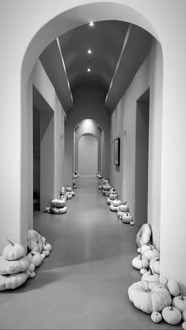 <p>Kourtney Kardashian/ Instagram</p> Kourtney set up nearly two dozen white pumpkins in a hallway in her home.