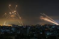 <p>14. Mai: Israelische Flugabwehrgeschütze (links) steigen in den Himmel über dem Gaza-Streifen, um die Angriffe der von der palästinensischen Hamas abgefeuerten Raketen (rechts) zu stoppen. (Bild: Anas Baba / AFP via Getty Images)</p> 