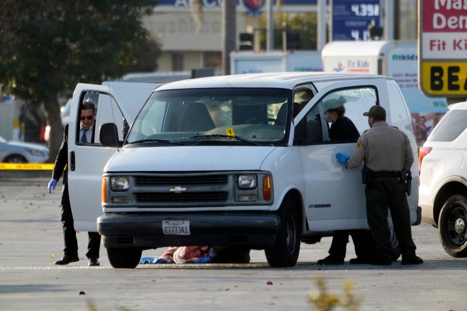 Authorities search a white cargo van for evidence.