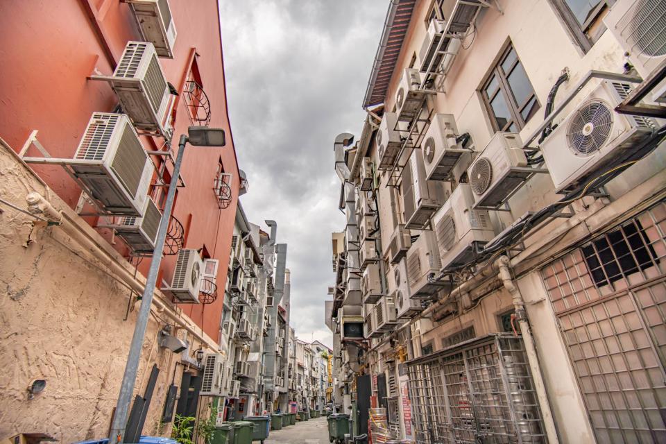 Multiple air conditioning condenser units on the back of buildings in Singapore.