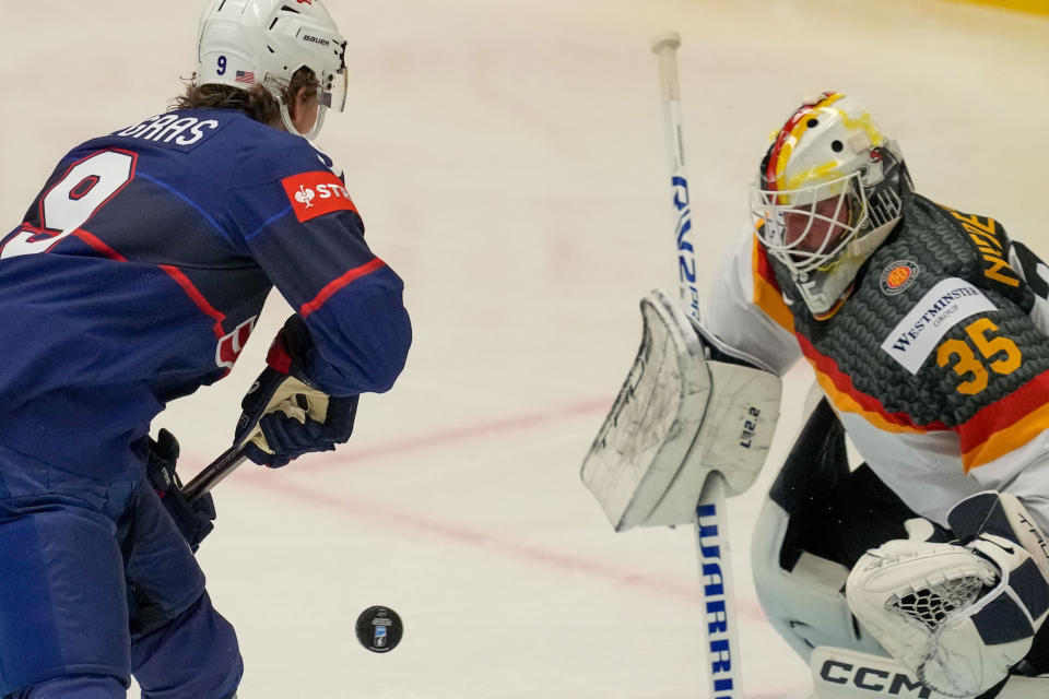 Germany's goalkeeper Mathias Niederberger, right, makes a save in front of Unted States' Trevor Zegras during the preliminary round match between United States and Germany at the Ice Hockey World Championships in Ostrava, Czech Republic, Saturday, May 11, 2024. (AP Photo/Darko Vojinovic)