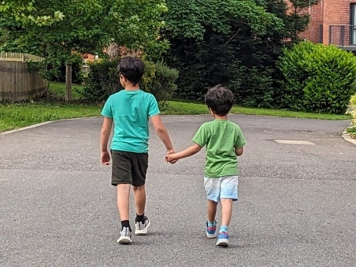 Two young boys walking and holding hands