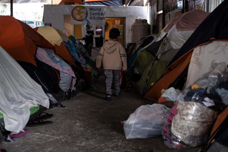 A migrant boy walks amid tents at a migrant shelter in Tijuana, Mexico, on December 17, 2020. / Credit: GUILLERMO ARIAS/AFP via Getty Images