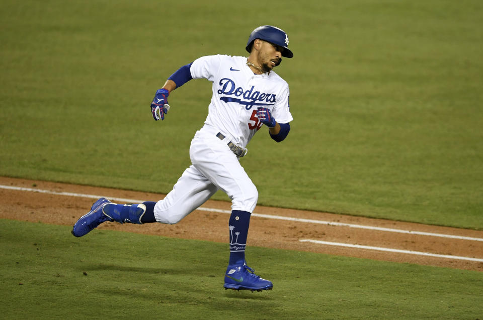 Mookie Betts #50 of the Los Angeles Dodgers rounds first on a two RBI double against the Milwaukee Brewers in the fifth inning of Game 2 of a National League wild-card baseball series MLB baseball game at Dodger Stadium in Los Angeles on Thursday, October 1, 2020. (Keith Birmingham/The Orange County Register via AP)