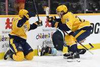 Nashville Predators defenseman Tyson Barrie (22) celebrates with center Philip Tomasino (26) after Barrie scored against the Seattle Kraken during the second period of an NHL hockey game Saturday, March 25, 2023, in Nashville, Tenn. (AP Photo/Mark Zaleski)