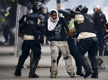 National police detain an anti-government protester during a protest against Nicolas Maduro's government in Caracas March 13, 2014. REUTERS/Carlos Garcia Rawlins