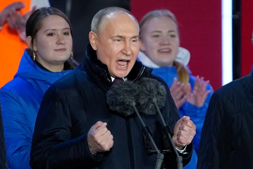 Russian President Vladimir Putin gestures while addressing a crowd at a concert marking his victory in a presidential election and the 10-year anniversary of Crimea's annexation by Russia on Red Square in Moscow, Russia, Monday, March 18, 2024. President Vladimir Putin seized Crimea from Ukraine a decade ago, a move that sent his popularity soaring but was widely denounced as illegal.