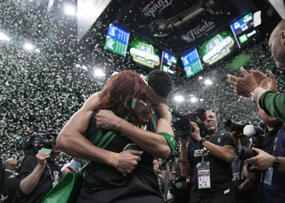 Boston Celtics forward Jayson Tatum, center right, embraces his mother Brandy Cole, center left, as he celebrates with the team after they won the NBA basketball championship with a Game 5 victory over the Dallas Mavericks, Monday, June 17, 2024, in Boston. (AP Photo/Charles Krupa)