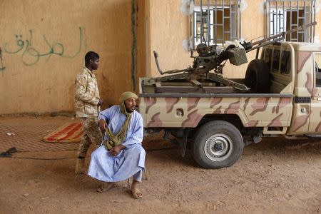 A Libyan Touareg man sits at a Libyan passport control post near the border with Algeria May 29, 2014. REUTERS/Ahmed Jadallah