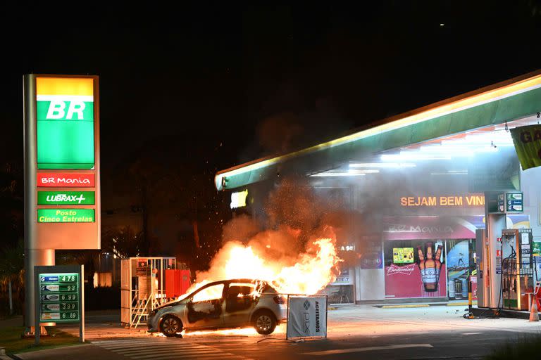 Un vehículo arde en una gasolinera tras los enfrentamientos entre la policía antidisturbios y los partidarios del presidente Jair Bolsonaro que protestaban por la detención de un líder indígena en Brasilia, el 12 de diciembre de 2022.