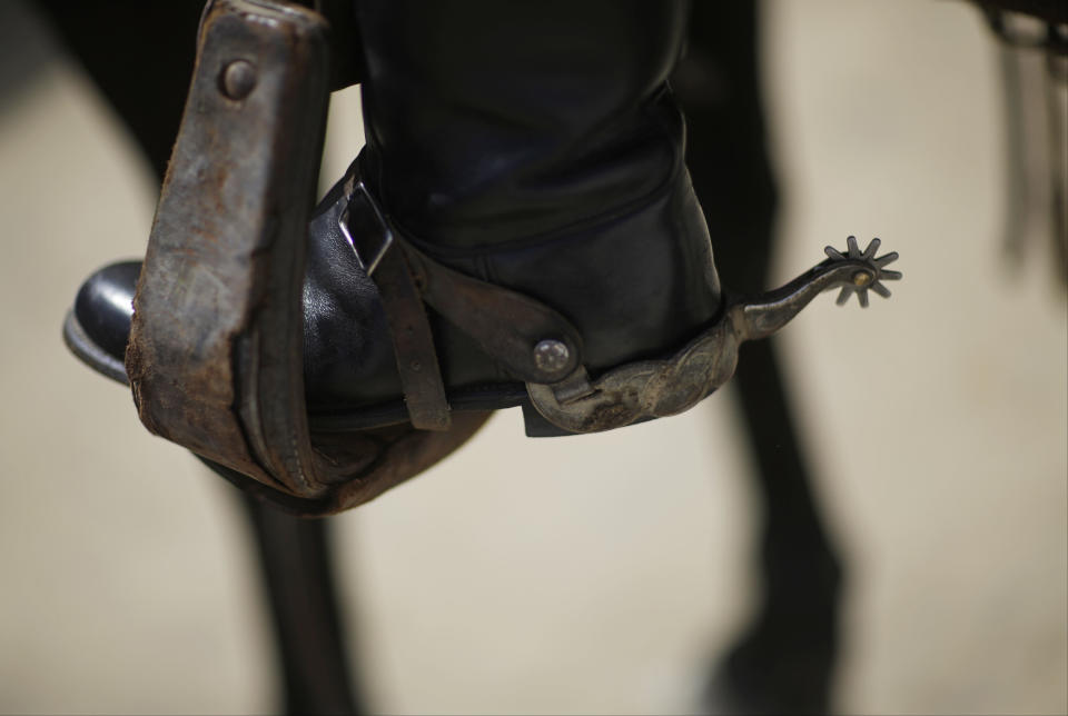 The heel of an outrider is seen following a race before the 140th running of the Kentucky Derby horse race at Churchill Downs Saturday, May 3, 2014, in Louisville, Ky. (AP Photo/David Goldman)