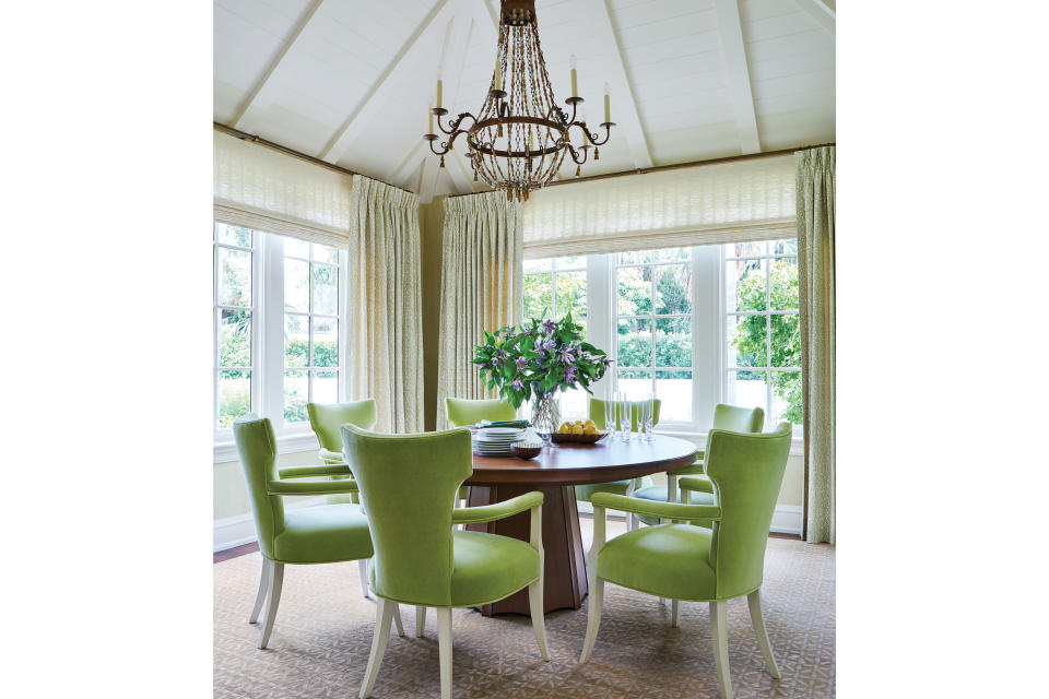 <p>Sharpe aimed for simplicity in the dining room, where a paneled, vaulted ceiling and views of the tropical landscape bring built-in beauty. She emphasized the organic elements with a loose garden theme that echoes the verdant greenery: chairs upholstered in chartreuse velvet, a subtle leaf print framing the windows, and a trellis-patterned rug. “When the sun crosses the room, the light is really lovely, and it makes the silk in the rug shimmer,” she says. The chandelier’s draped wooden beading is another nod to the tropical environment. The walnut pedestal table is by <a href="https://www.bakerfurniture.com/" rel="nofollow noopener" target="_blank" data-ylk="slk:Baker;elm:context_link;itc:0;sec:content-canvas" class="link ">Baker</a>.</p>