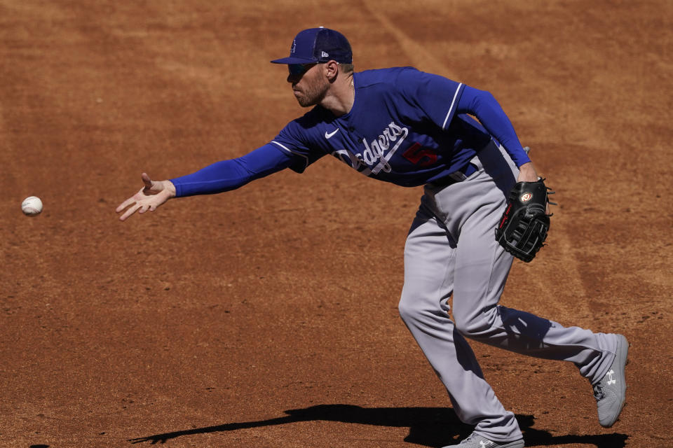 Los Angeles Dodgers' Freddie Freeman (5) fields a ground out hit by Colorado Rockies' Bret Boswell during the third inning of a spring training baseball game Thursday, March 24, 2022, in Scottsdale, Ariz. (AP Photo/Matt York)