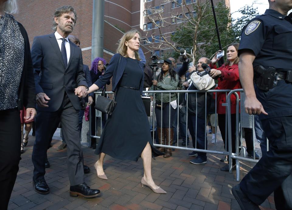 Felicity Huffman leaves federal court with her husband, William H. Macy, wearing a navy dress and jacket on Sept. 13, 2019, in Boston. (Photo: ASSOCIATED PRESS)