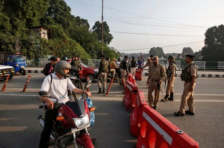 Indian security personnel stop people during restrictions in Srinagar