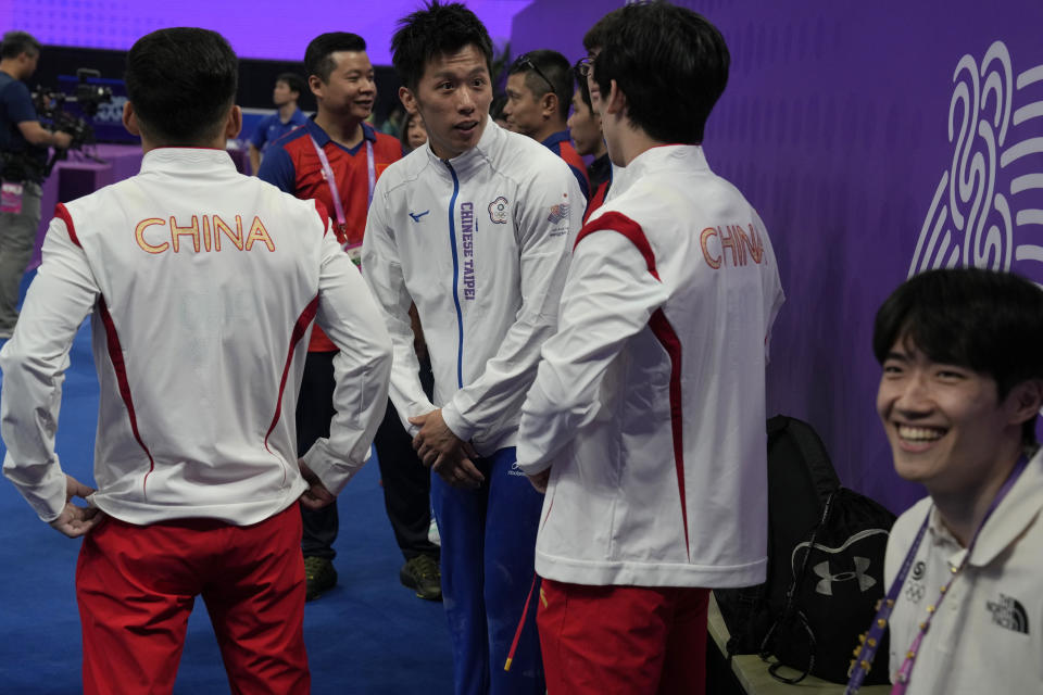 China's Lin Chaopan, at left congratulates Taiwan's Lee Chih Kai after he wins Artistic Gymnastics Men's Pommel Horse Final next to China's Zhang Boheng, during the 19th Asian Games in Hangzhou, China, Thursday, Sept. 28, 2023. At the Asian Games China has been going out of its way to be welcoming to the Taiwanese athletes, as it pursues a two-pronged strategy with the goal of taking over the island, which involves both wooing its people while threatening it militarily. (AP Photo/Ng Han Guan)