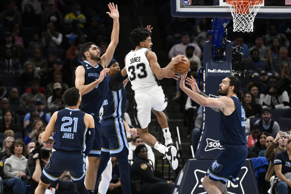 San Antonio Spurs guard Tre Jones (33) passes the ball from between Memphis Grizzlies guard Tyus Jones (21), forwards Santi Aldama (7) and Ziaire Williams and center Steven Adams (4) during the first half of an NBA basketball game Wednesday, Jan. 11, 2023, in Memphis, Tenn. (AP Photo/Brandon Dill)