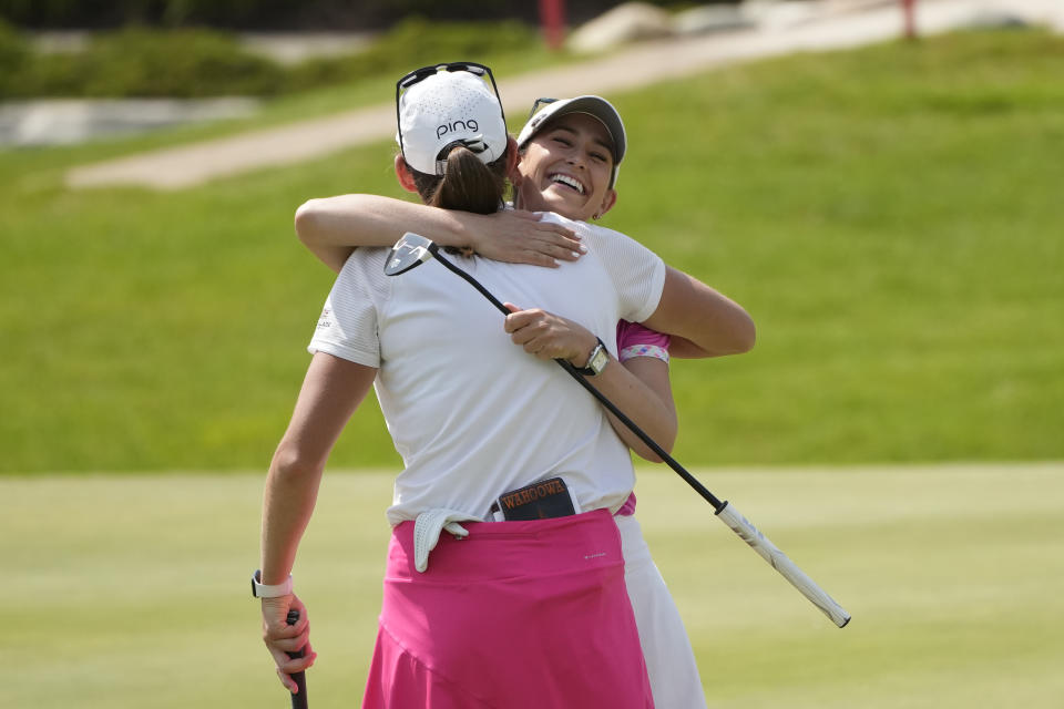 Cheyenne Knight, rear, hugs Elizabeth Szokol on the 18th green during the third round of the Dow Great Lakes Bay Invitational golf tournament at Midland Country Club, Friday, July 21, 2023, in Midland, Mich. (AP Photo/Carlos Osorio)