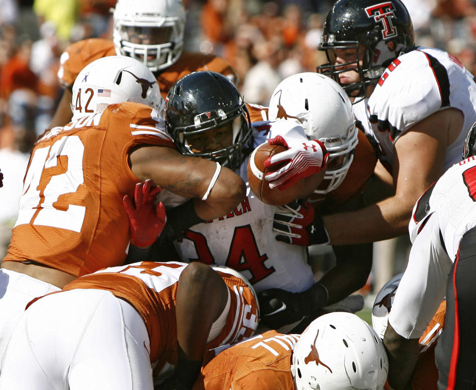 AUSTIN, TX - NOVEMBER 5: Running back Kenny Williams #34 of the Texas Tech Red Raiders is stopped from scoring on the goal line in the fourth quarter by linebacker Tevin Jackson #42 and other Texas Longhorn defenders on November 5, 2011 at Darrell K. Royal-Texas Memorial Stadium in Austin, Texas. Texas beat Texas Tech 52-20. (Photo by Erich Schlegel/Getty Images)