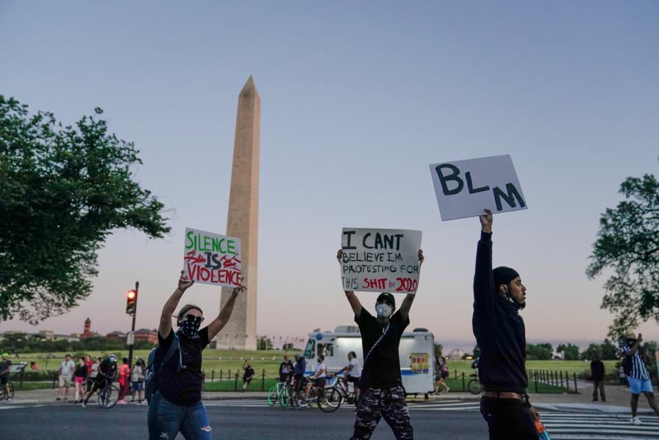 Demonstrators march past the Washington Monument as they protest the death of George Floyd on May 31, 2020.