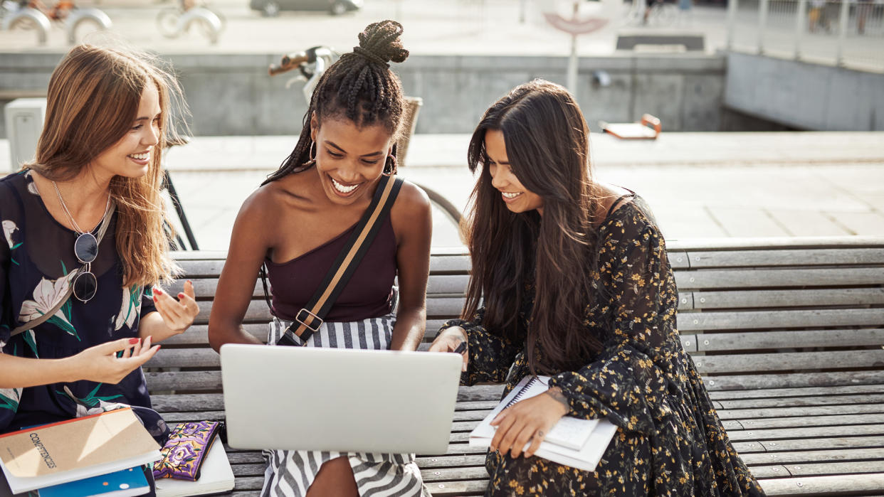 Shot of young women studying together outdoors.