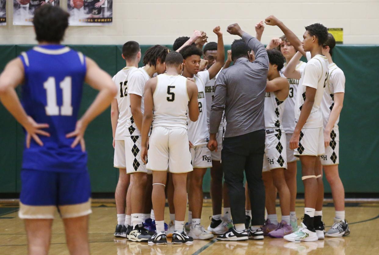 Rush-Henrietta players all huddle up around head coach Calvin Betts before taking the court to take on Webster Schroeder during their Section V boys basketball game Wednesday, Dec. 20, 2023 at Rush-Henrietta High School.