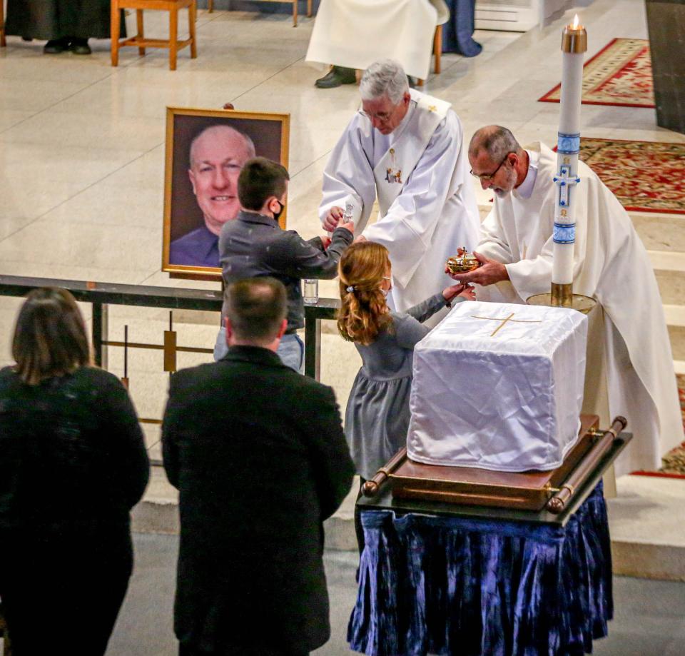 The family of Gerald Habershaw offer gifts during his funeral Mass on Saturday.