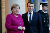 French President Emmanuel Macron (R) greets German Chancellor Angela Merkel upon her arrival at the Elysee Palace in Paris, France, January 19, 2018. REUTERS/Charles Platiau