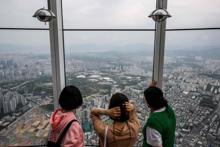 Varias mujeres disfrutan de la vista de la ciudad desde el rascacielos más alto de Seúl.