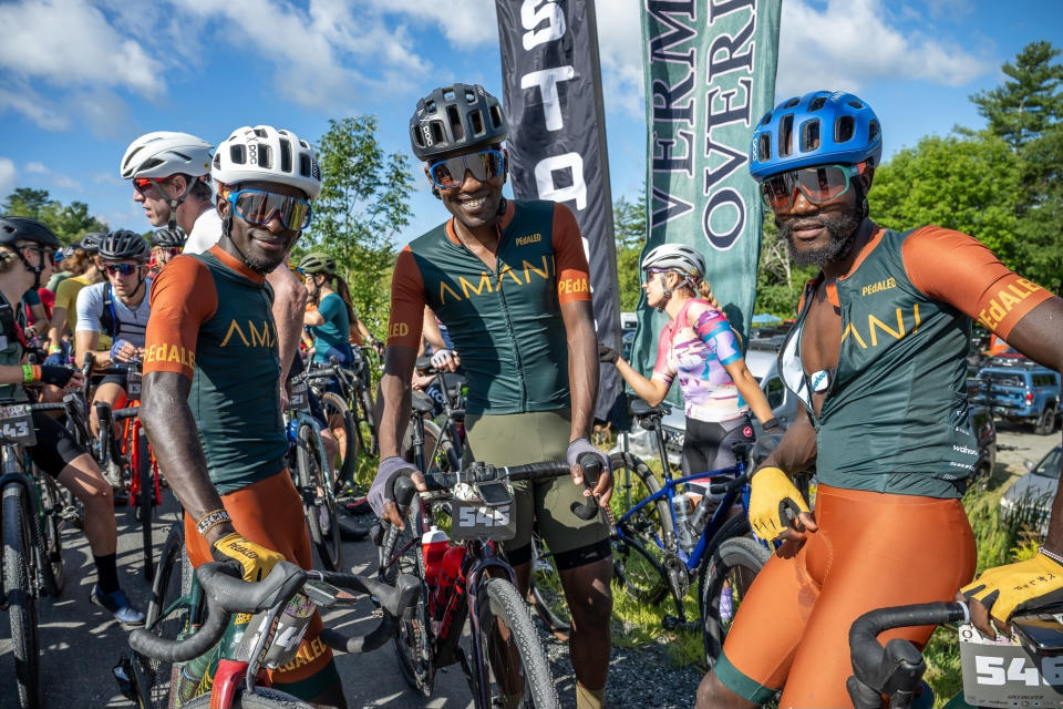 In this photo provided by Joseph Viger, Kenyan cyclist Sule Kangangi, center, poses with others for a picture at a gravel race, in Vermont, Saturday, Aug. 27, 2022. Kangangi died in a crash later in the day, while competing in the race. (Joseph Viger via AP)