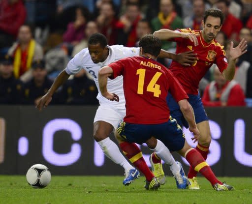 El defensa francés Patrice Evra maniobra ante la marca de los españoles Xabi Alonso (C) y Juanfran (D), en partido de clasificación para el Mundial 2014 disputado en el estadio Vicente Calderón de Madrid, el 16 de octubre de 2012. (AFP | javier soriano)