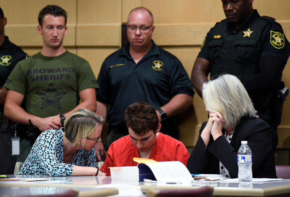 Nikolas Cruz sits with attorneys Melisa McNeill (left) and Diane Cuddihy (right), appointed by the Broward Public Defender's Office, on April 11.&nbsp; (Photo: POOL New / Reuters)