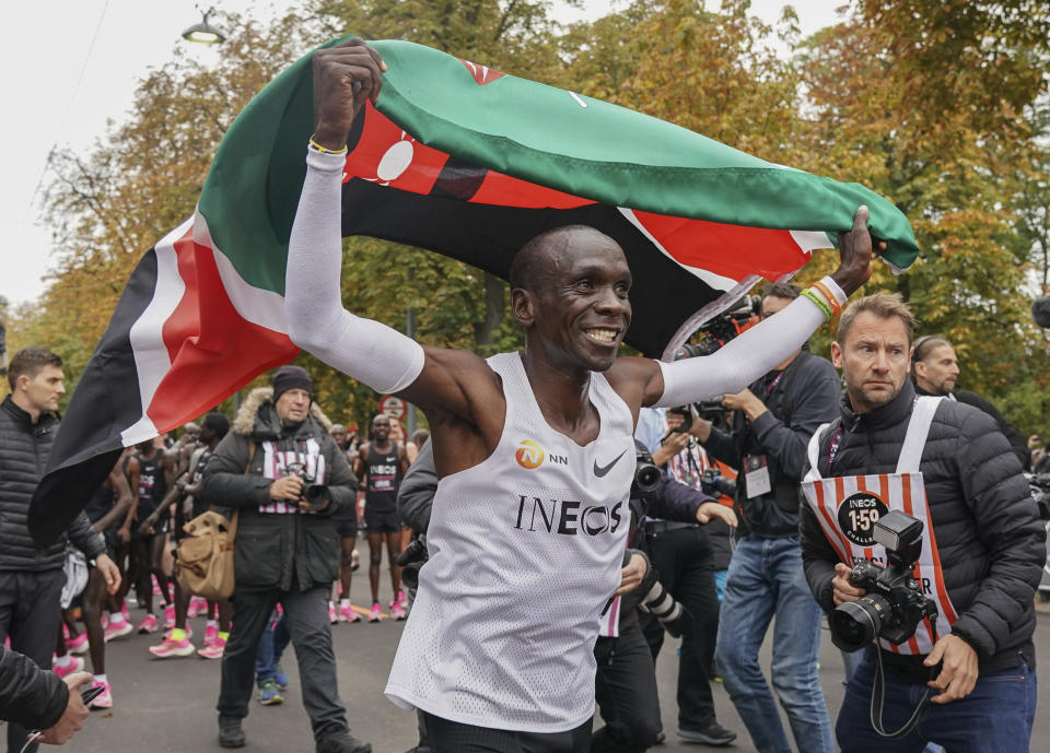 Eliud Kipchoge celebrates with the Kenyan flag after breaking the historic two hour barrier for a marathon in Vienna, Saturday, Oct. 12, 2019. Eliud Kipchoge has become the first athlete to run a marathon in less than two hours, although it will not count as a world record. The Olympic champion and world record holder from Kenya clocked 1 hour, 59 minutes and 40 seconds Saturday at the INEOS 1:59 Challenge, an event set up for the attempt. (Jed Leicester/The INEOS 1:59 Challenge via AP)