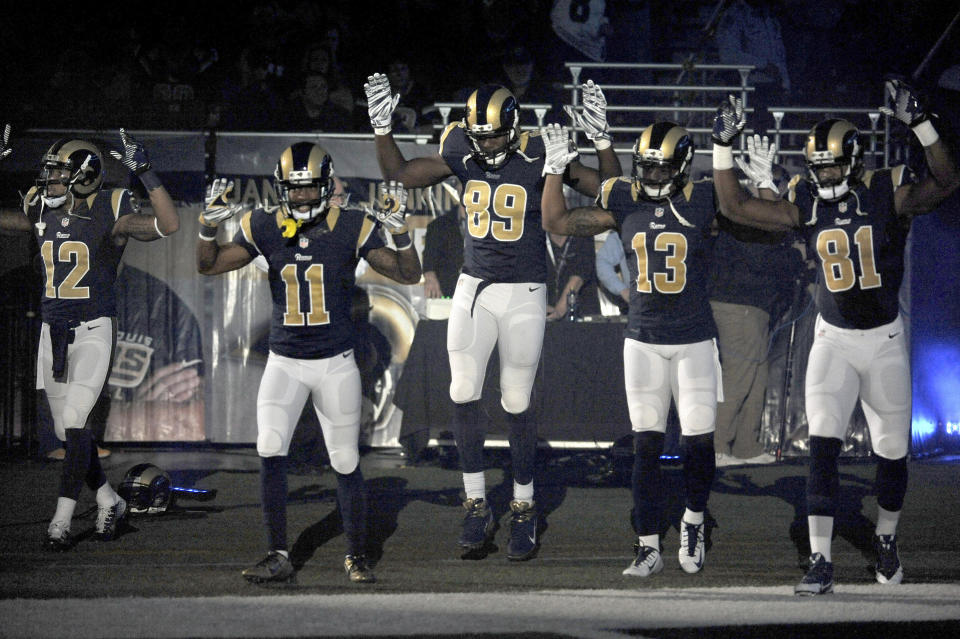 FILE - In this Nov. 30, 2014, file photo, St. Louis Rams players, from left, Stedman Bailey (12), Tavon Austin (11), Jared Cook, (89) Chris Givens (13) and Kenny Britt (81) raise their arms in awareness of the events in Ferguson, Mo., as they walk onto the field during introductions before an NFL football game against the Oakland Raiders in St. Louis. The players said after the game, they raised their arms in a "hands up" gesture to acknowledge the events in Ferguson. (AP Photo/L.G. Patterson, File)