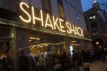Passersby walk in front of the Shake Shack restaurant in the Manhattan borough of New York, December 29, 2014. REUTERS/Keith Bedford