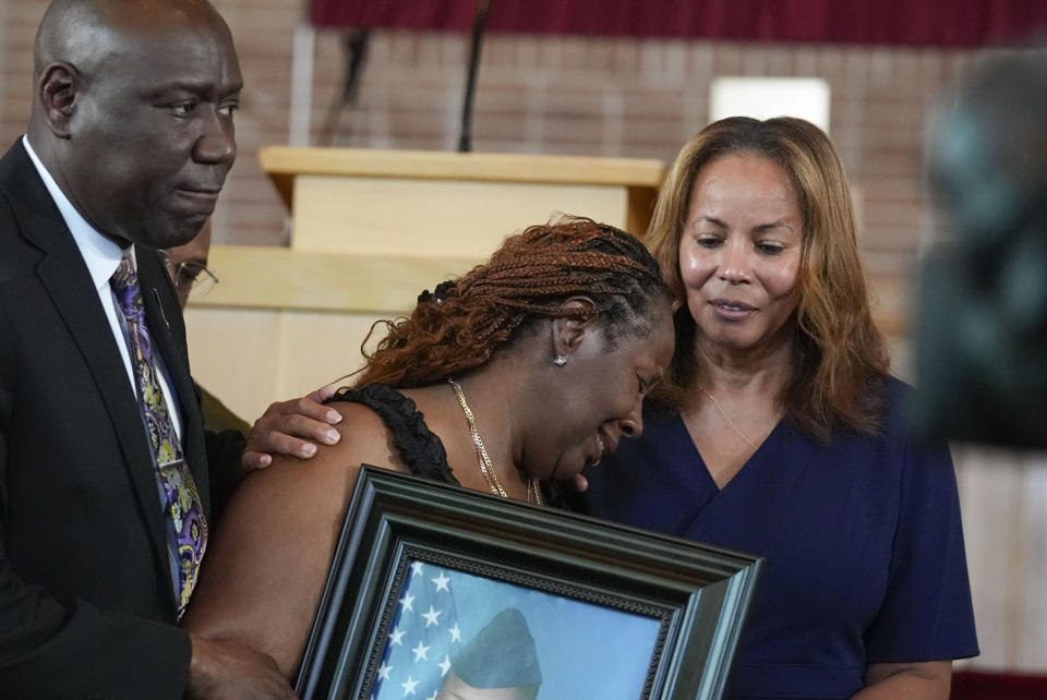 Chantemekki Fortson, mother of slain Roger Fortson, a U.S. Air Force senior airman, breaks down in tears holding a photo of her son during a news conference with attorney Ben Crump on Monday, June 3, 2024, in Atlanta. (AP Photo/Brynn Anderson)