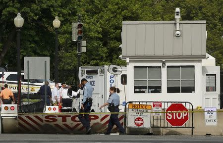 Police officers walk past the location of a shooting near a White House gate in Washington, DC, U.S. May 20, 2016. REUTERS/Jonathan Ernst