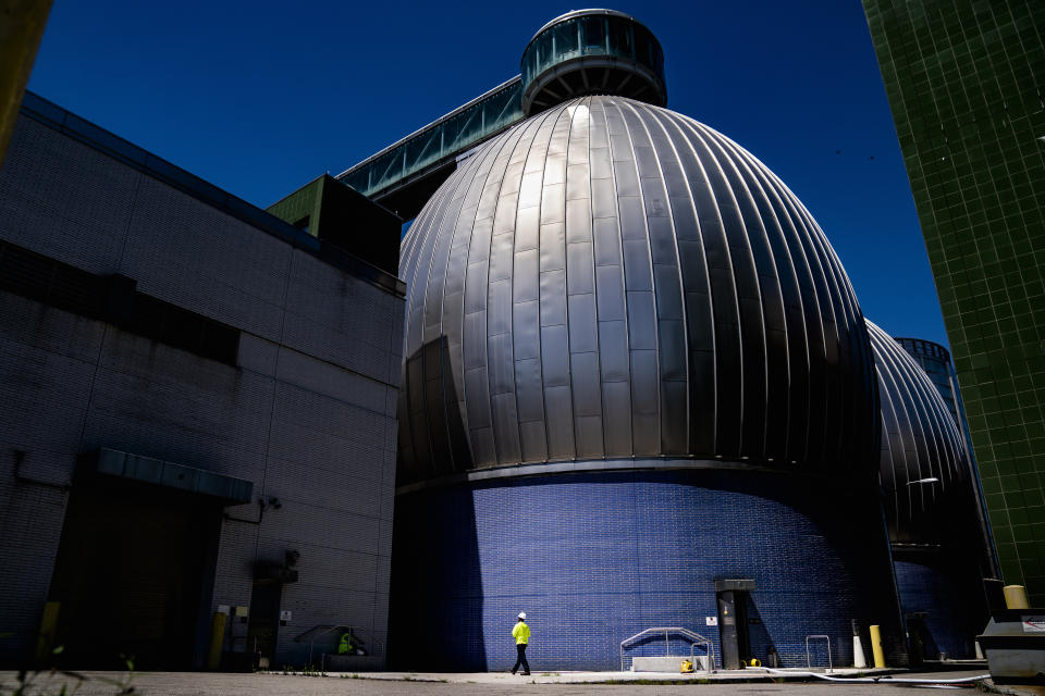 FILE - A worker walks alongside the Newtown Creek Wastewater Treatment Plant's array of digester eggs, Aug. 12, 2022, in the Greenpoint neighborhood of the Brooklyn borough of New York. In the U.S., an unvaccinated young adult suffered paralysis in his legs after being infected with polio, New York officials revealed last month. The virus has also shown up in New York sewers, suggesting it is spreading. (AP Photo/John Minchillo, File)