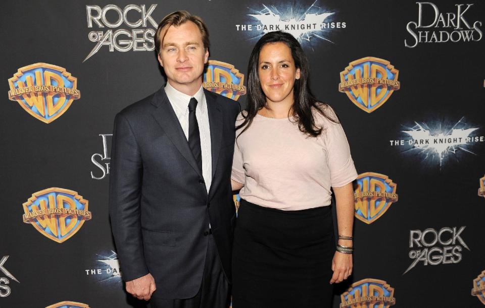 Christopher Nolan, left, director, co-writer and co-producer of the upcoming film "The Dark Knight Rises," poses with his wife Emma Thomas, also a co-producer of the film, backstage at CinemaCon 2012, the official convention of the National Association of Theater Owners, Tuesday, April 24, 2012, in Las Vegas. (AP Photo/Chris Pizzello)