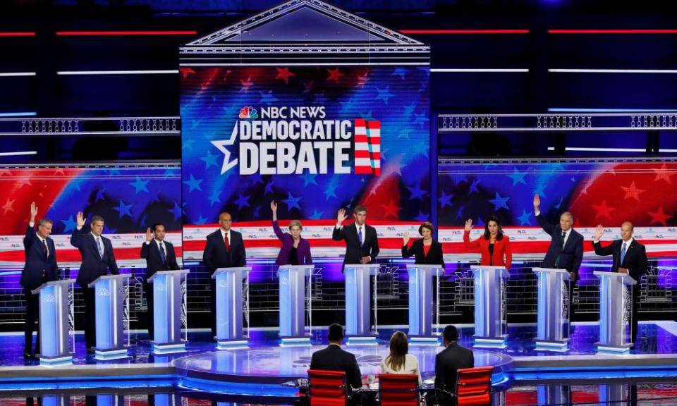 Candidates raise hands while responding to a question on the Iran nuclear deal